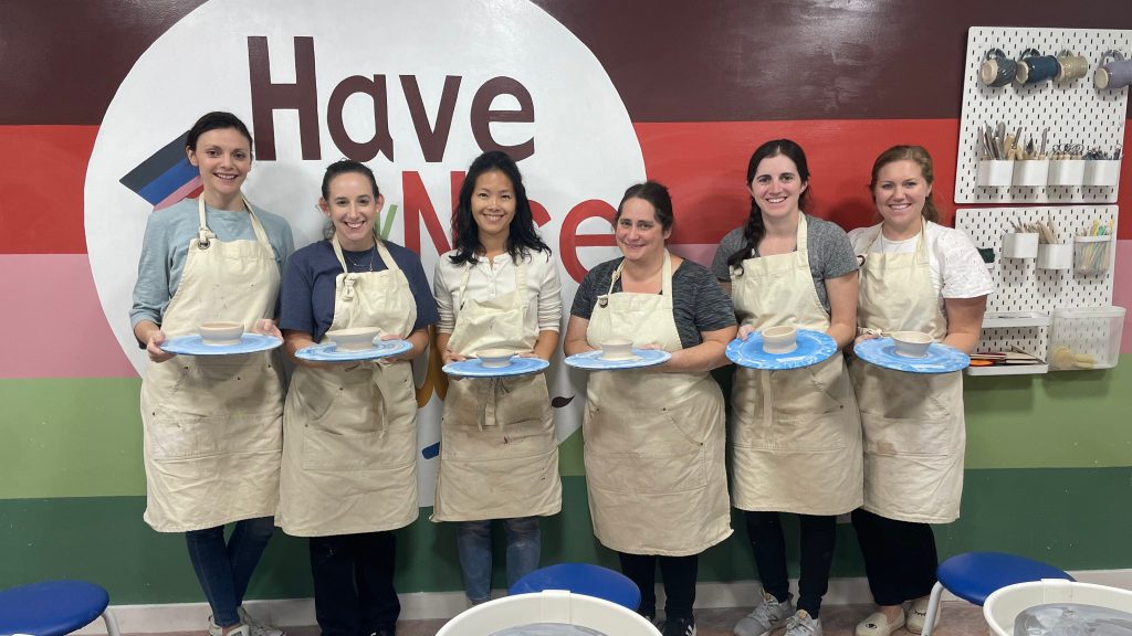 a group of moms enjoying an outing at a local pottery studio