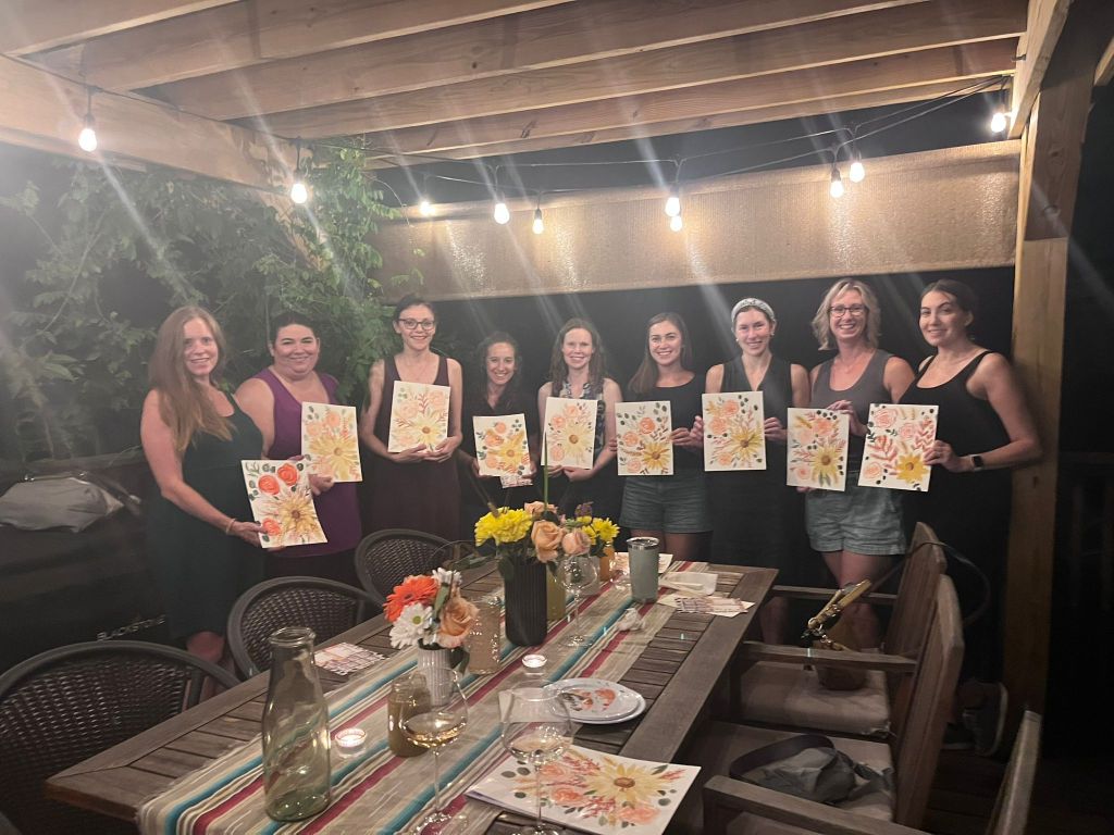 Moms showing off their watercolor paintings after taking a class together.